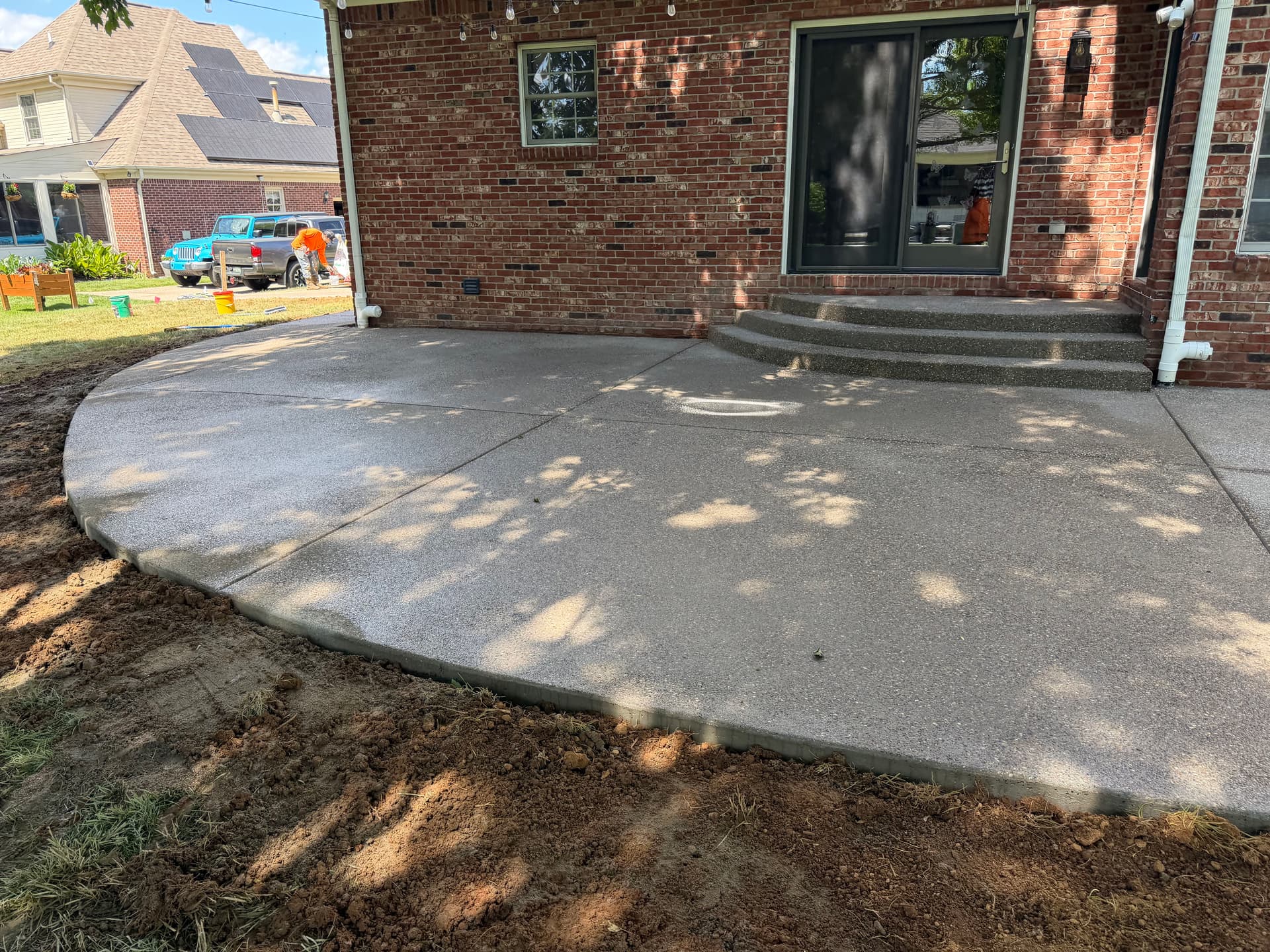 Gallery photos for Sunken Paver Patio Replaced With a Larger Exposed Concrete Outdoor Patio: Image #1